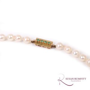 A Graduated Cultured Pearl Necklace with Emerald Clasp